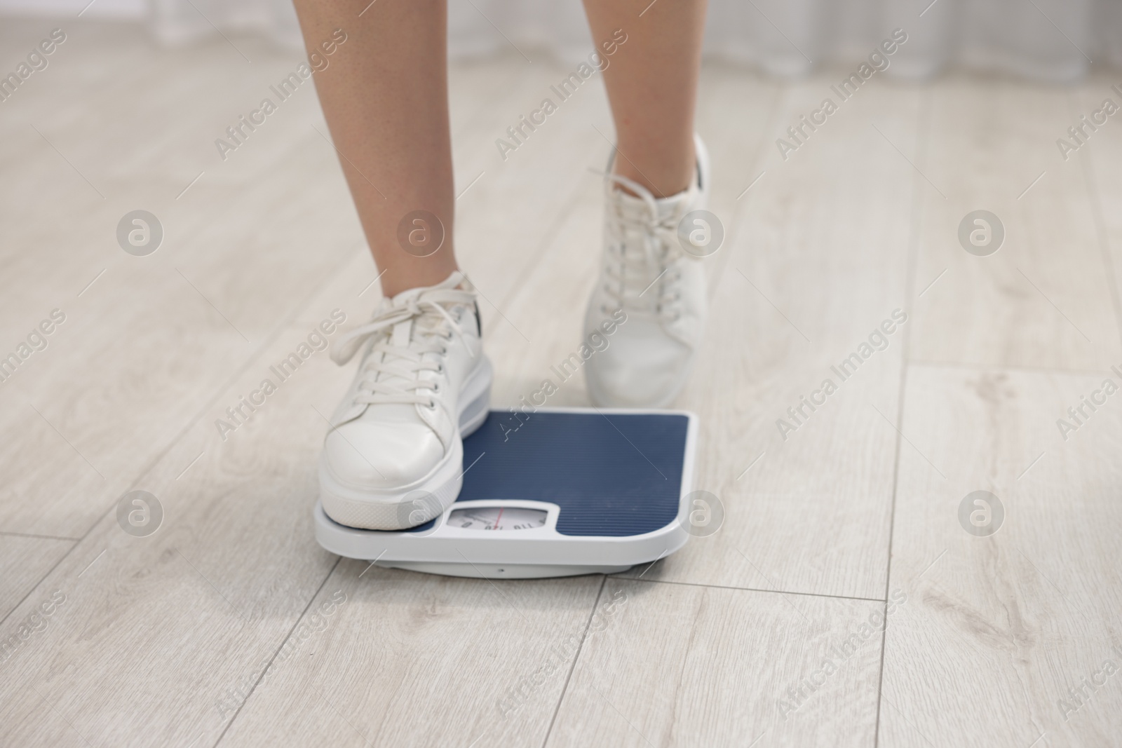 Photo of Woman on scales indoors, closeup. Weight loss