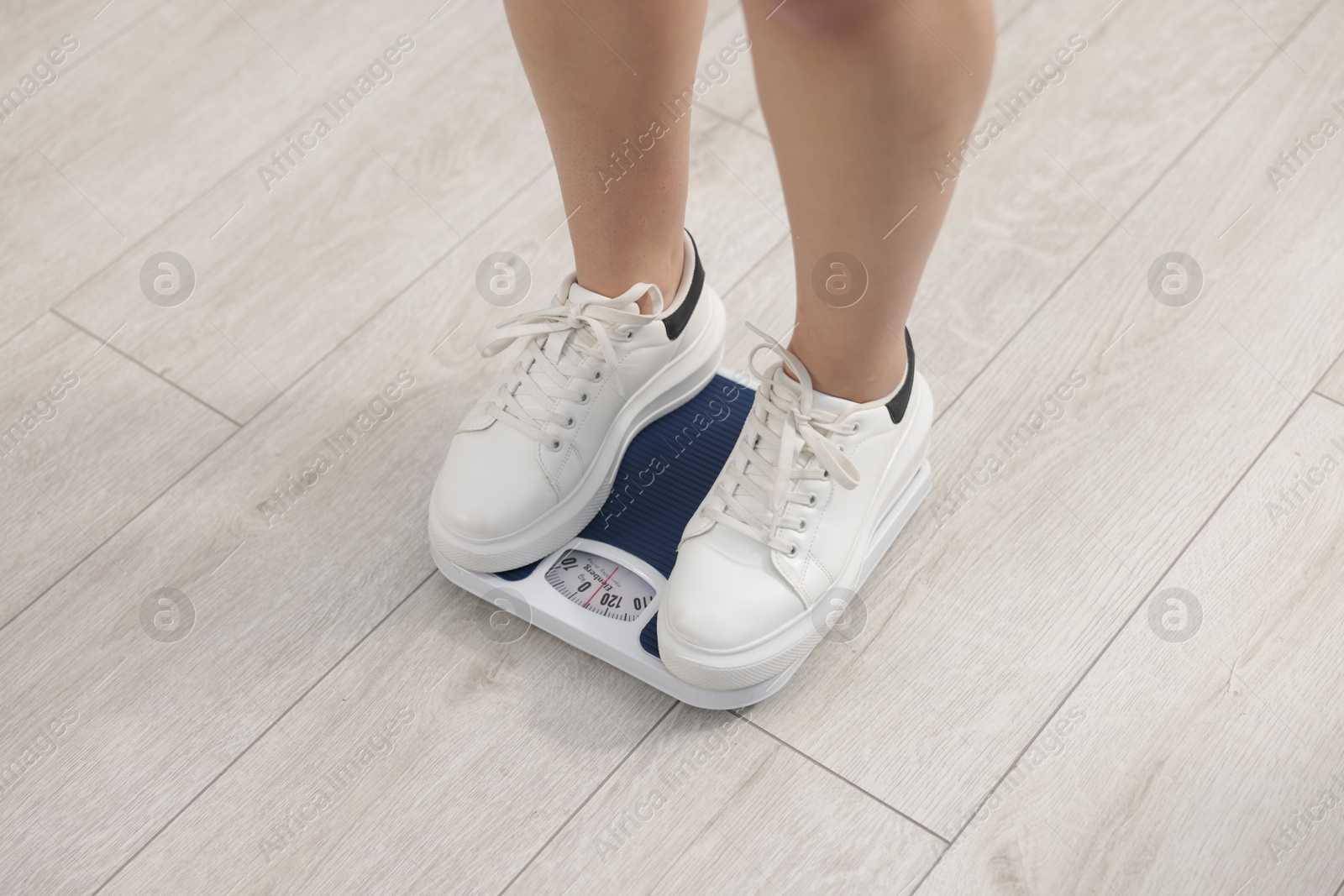 Photo of Woman on scales indoors, closeup. Weight loss