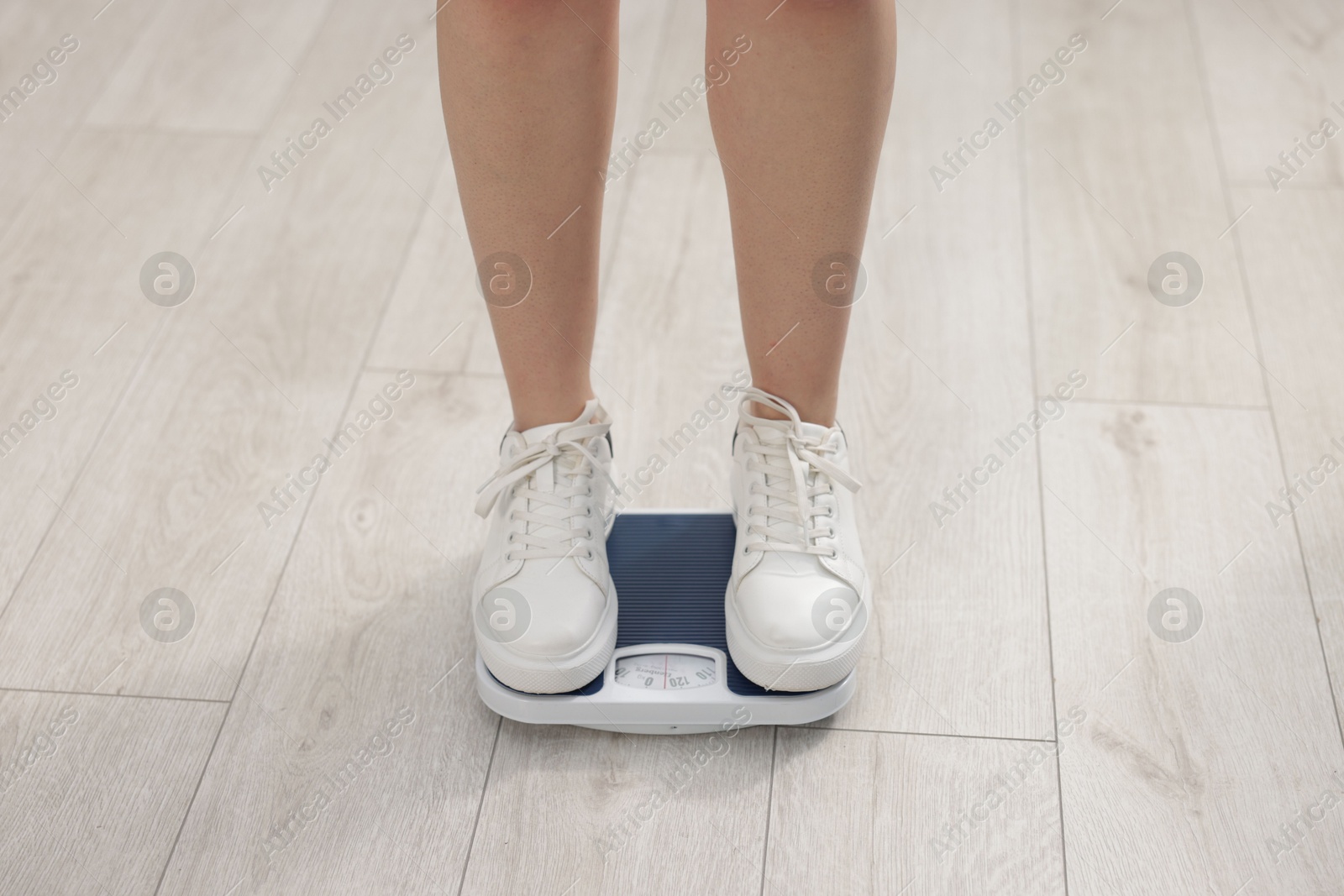 Photo of Woman on scales indoors, closeup. Weight loss