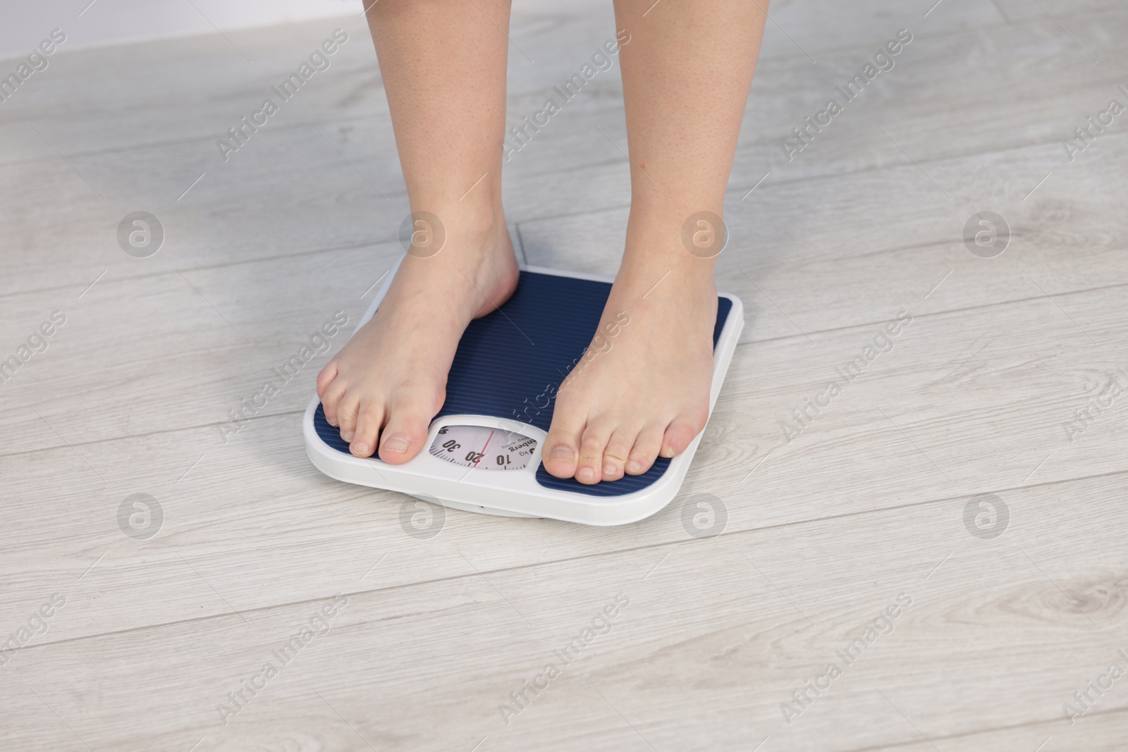 Photo of Woman on scales indoors, closeup. Weight loss