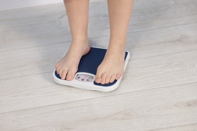 Photo of Woman on scales indoors, closeup. Weight loss