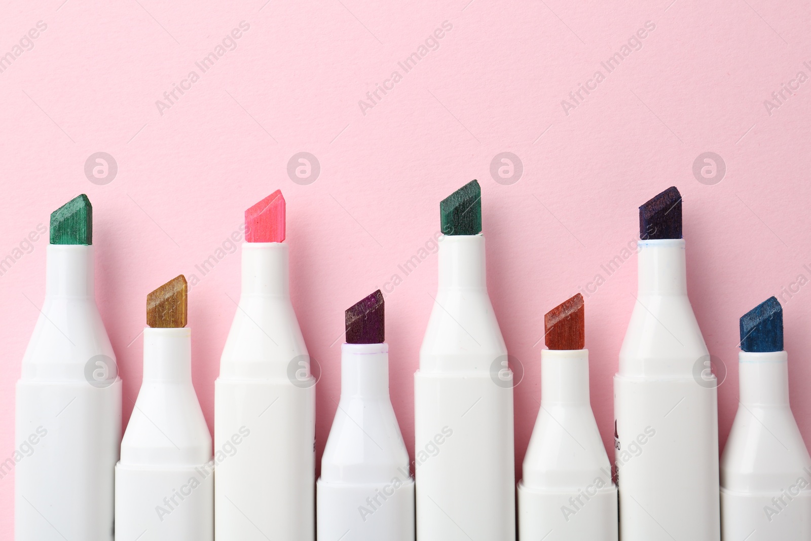 Photo of Colorful markers on pink background, flat lay