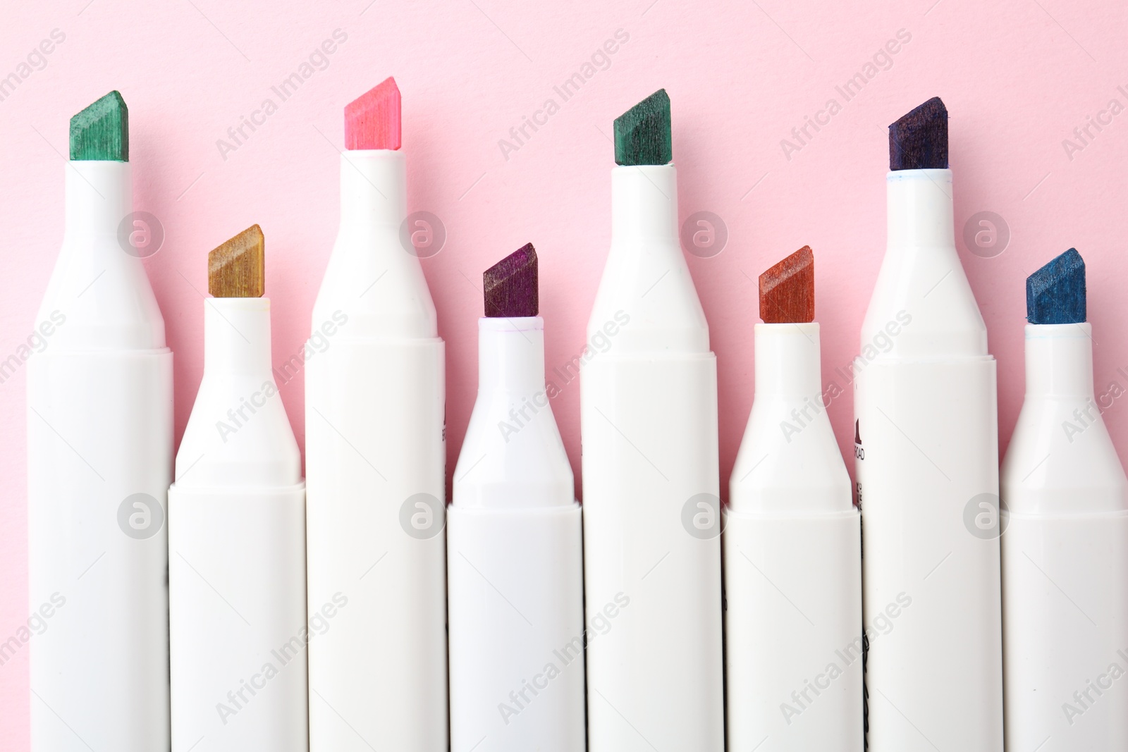 Photo of Colorful markers on pink background, flat lay