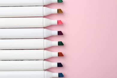 Photo of Colorful markers on pink background, flat lay. Space for text