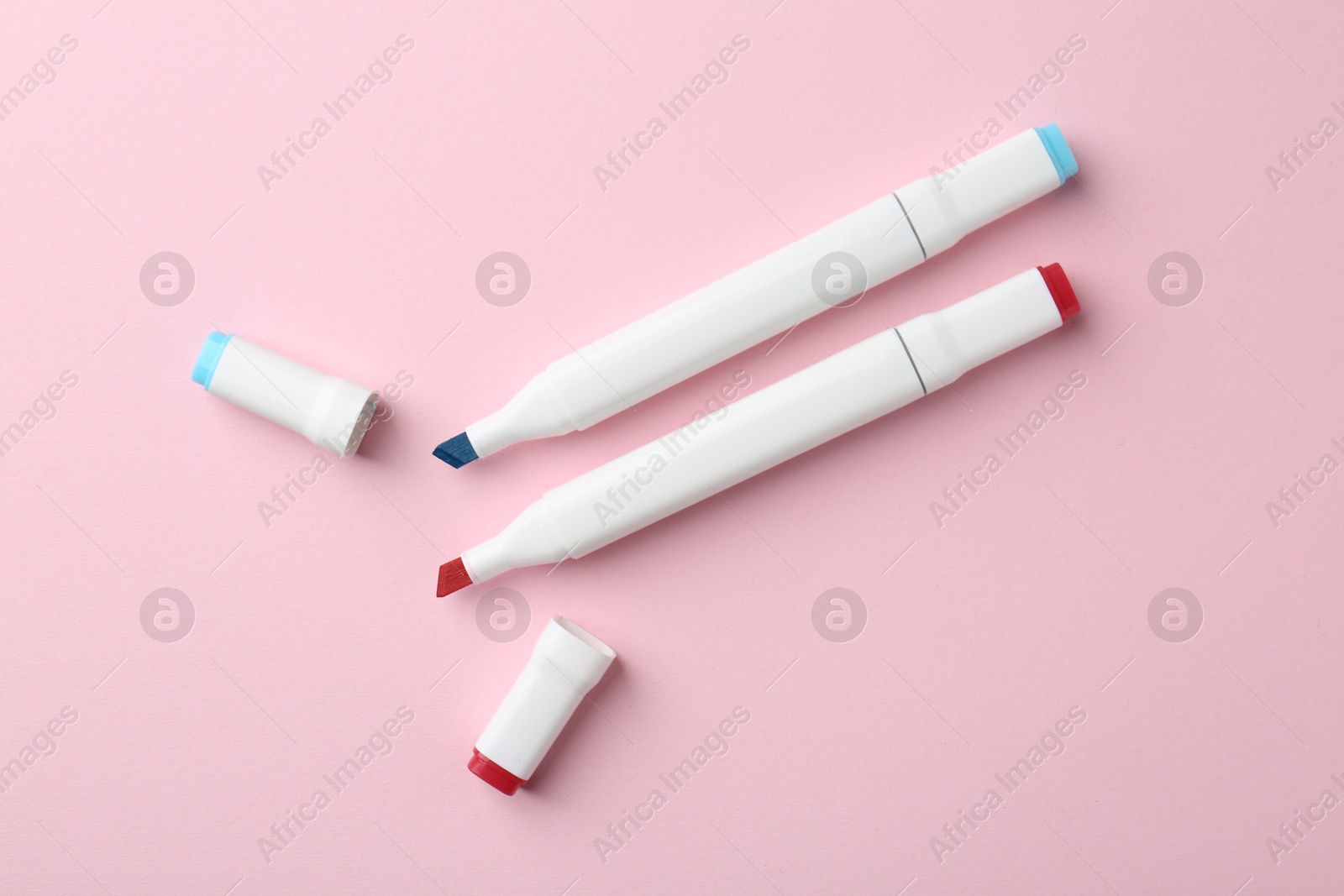 Photo of Two double sided markers on pink background, flat lay