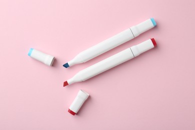 Two double sided markers on pink background, flat lay