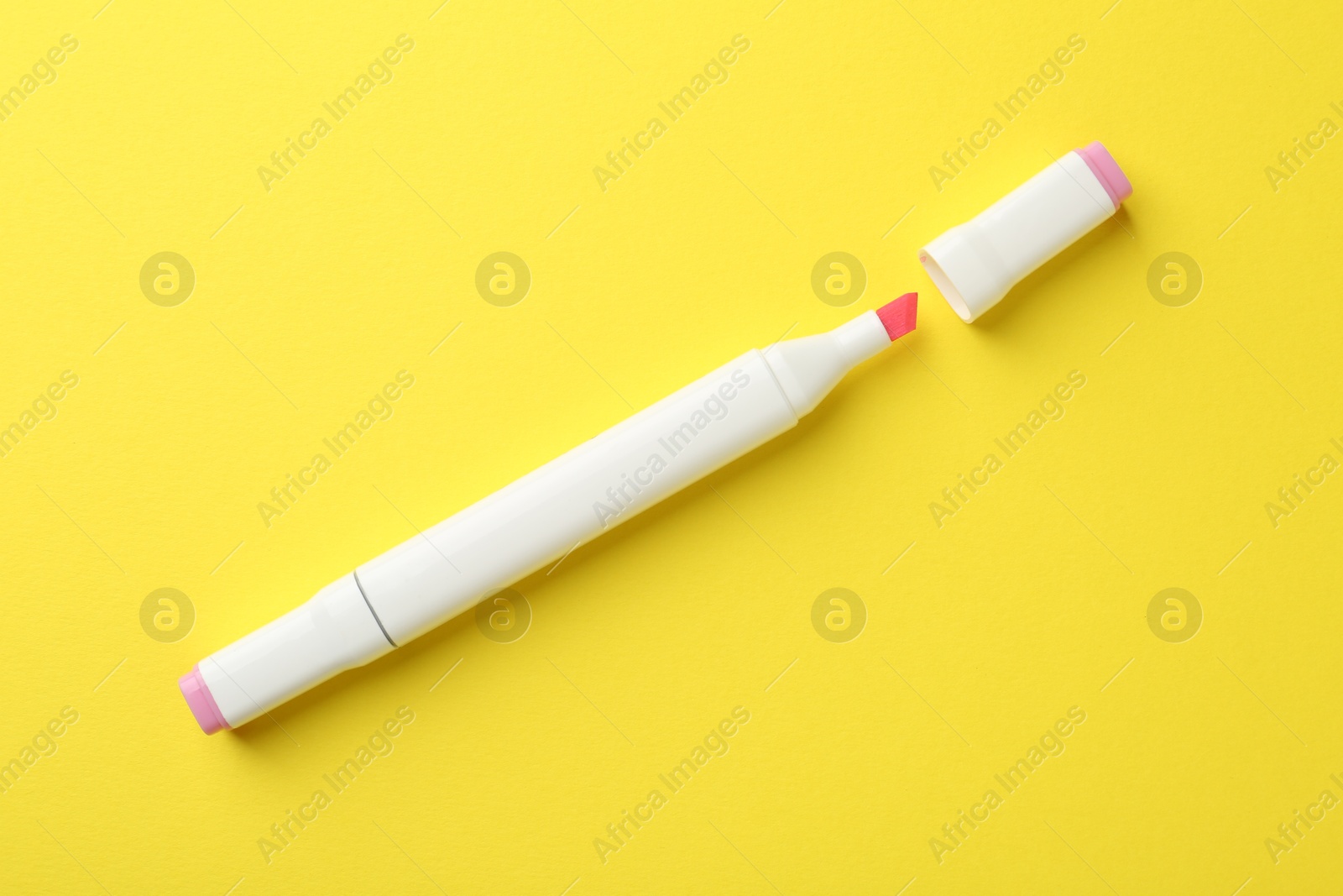 Photo of One pink double sided marker on yellow background, top view