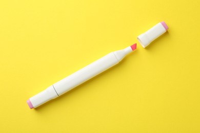 Photo of One pink double sided marker on yellow background, top view