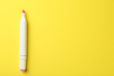 Photo of One pink double sided marker on yellow background, top view. Space for text