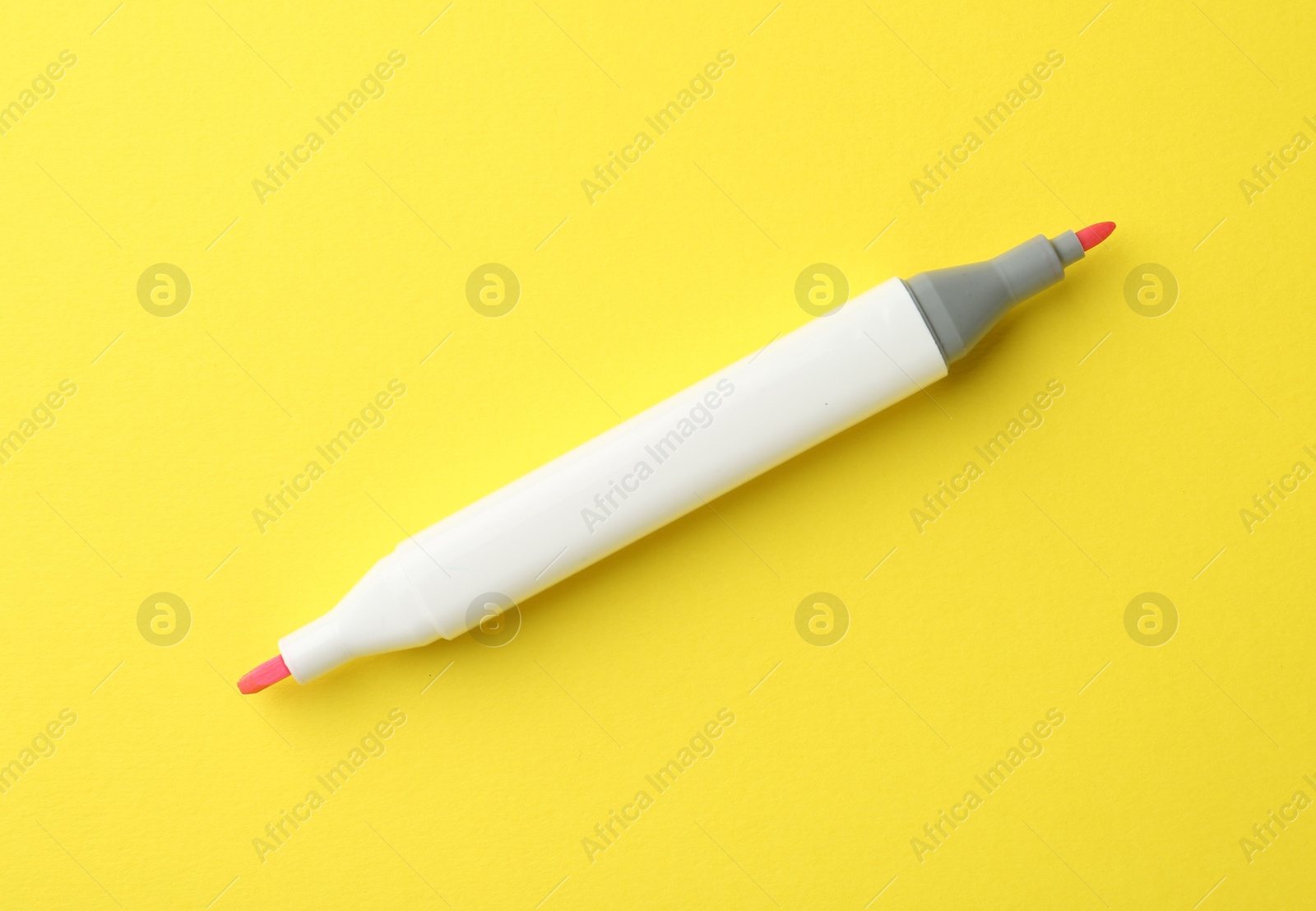 Photo of One pink double sided marker on yellow background, top view