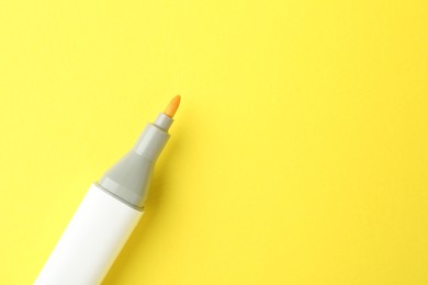 Photo of One color marker on yellow background, top view. Space for text