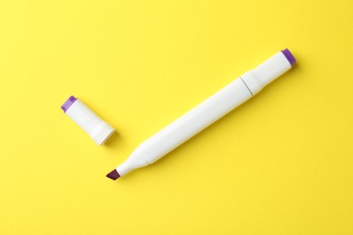 Photo of One color double sided marker on yellow background, top view