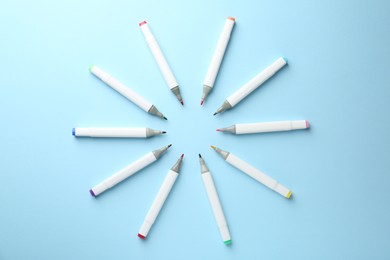 Photo of Colorful double sided markers on light blue background, flat lay