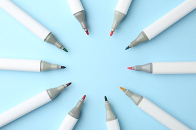 Photo of Colorful markers on light blue background, flat lay