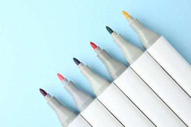 Photo of Colorful markers on light blue background, flat lay