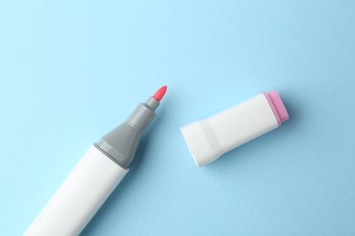 Photo of One color marker on light blue background, top view