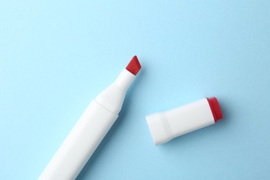 Photo of One color marker on light blue background, top view