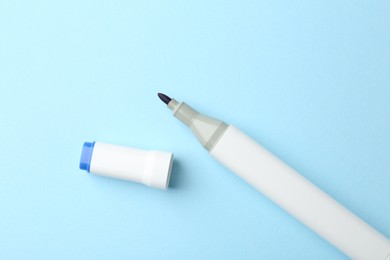 Photo of One color marker on light blue background, top view