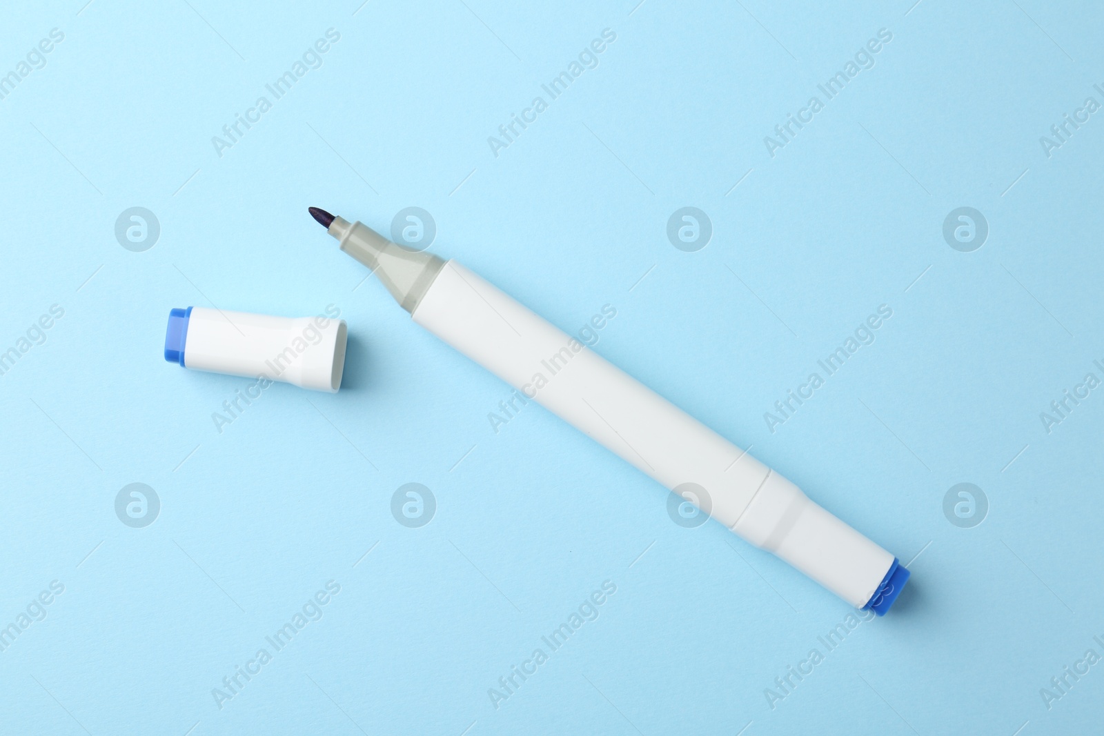 Photo of One color double sided marker on light blue background, top view