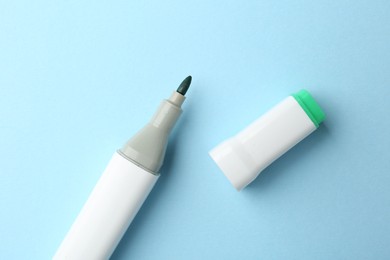 Photo of One color marker on light blue background, top view