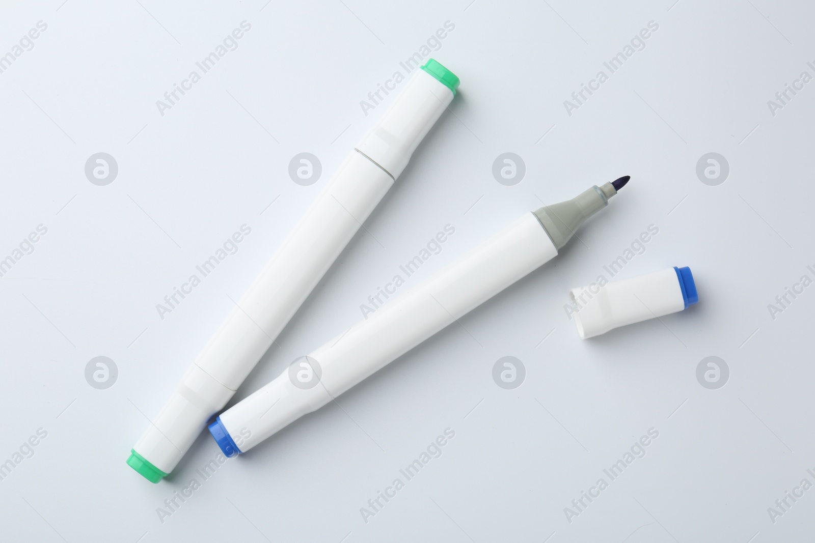 Photo of Colorful double sided markers on white background, flat lay