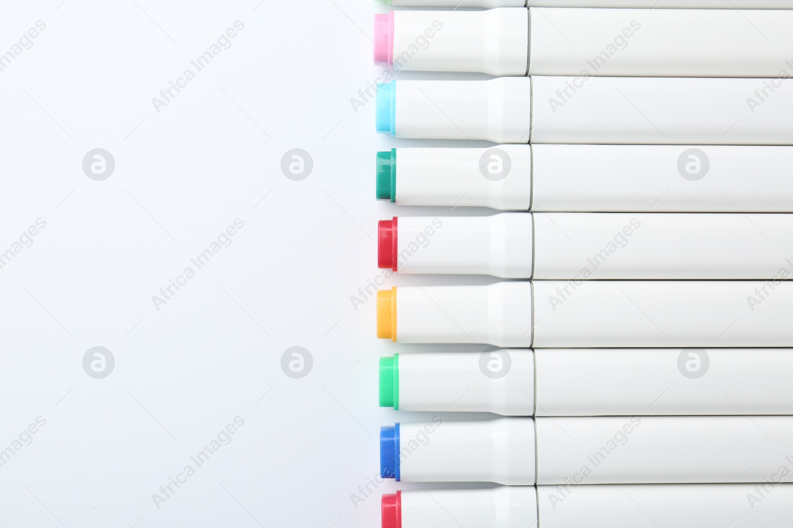 Photo of Colorful markers on white background, flat lay. Space for text