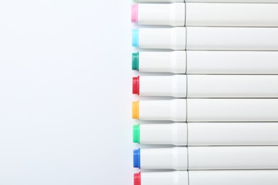 Colorful markers on white background, flat lay. Space for text