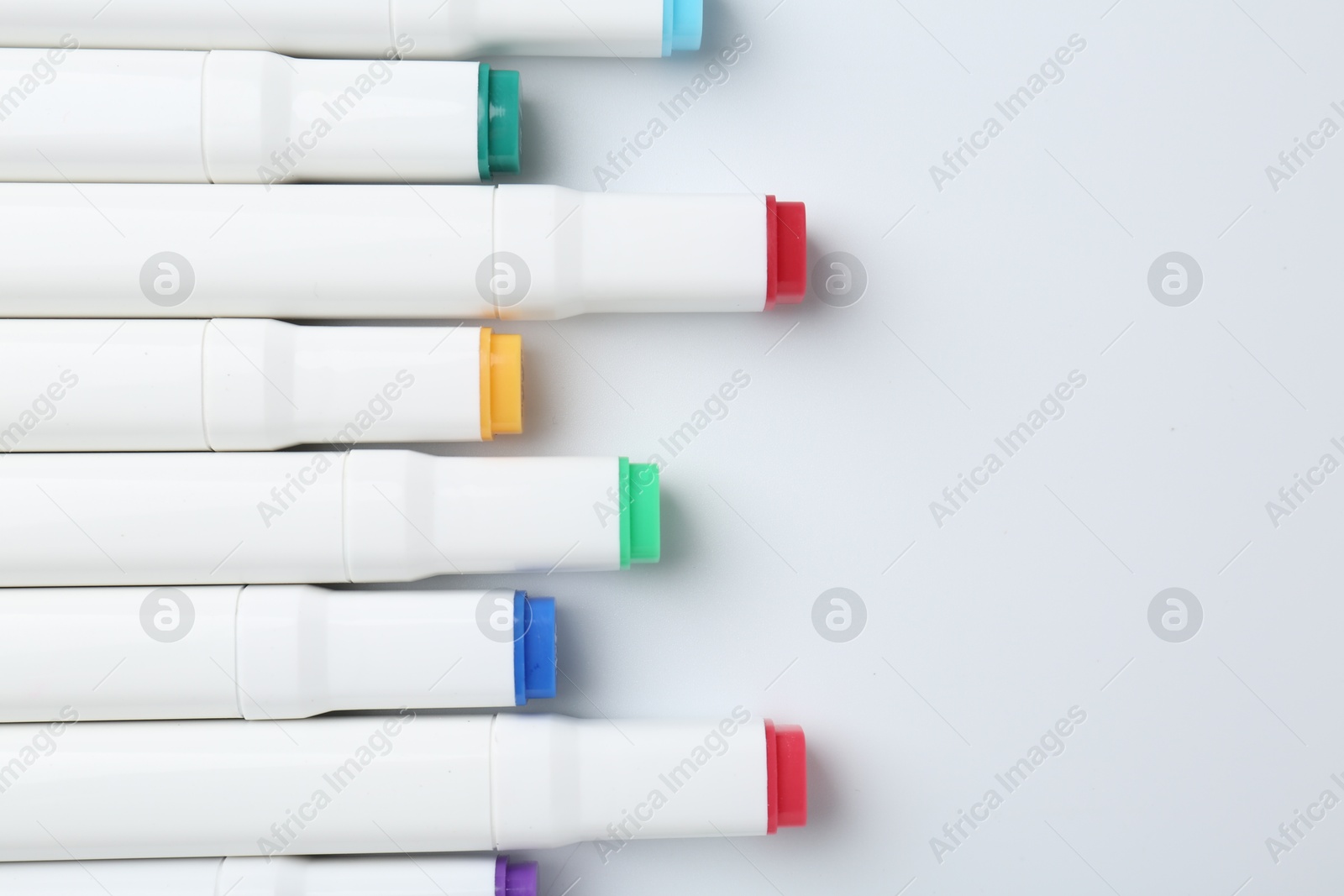 Photo of Colorful markers on white background, flat lay. Space for text