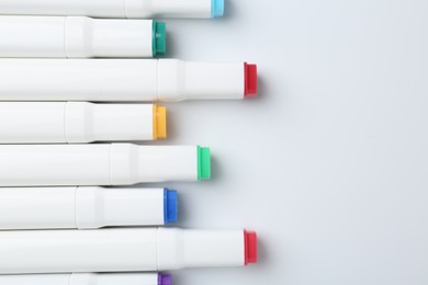 Photo of Colorful markers on white background, flat lay. Space for text