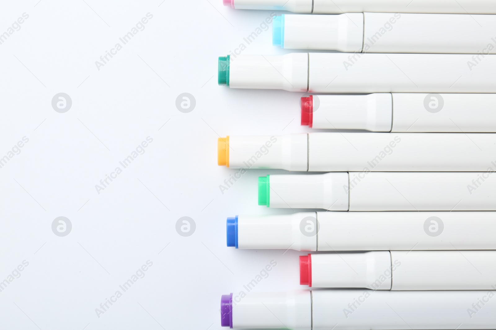 Photo of Colorful markers on white background, flat lay. Space for text