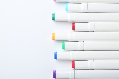 Colorful markers on white background, flat lay. Space for text