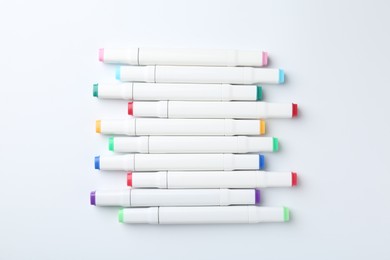 Photo of Colorful double sided markers on white background, flat lay