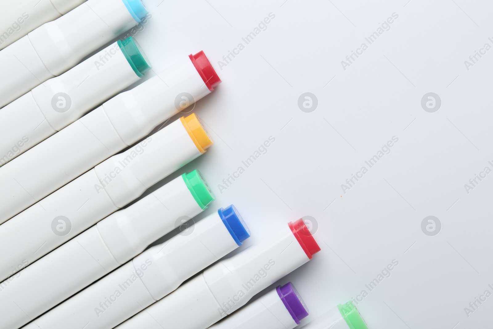 Photo of Colorful markers on white background, flat lay. Space for text