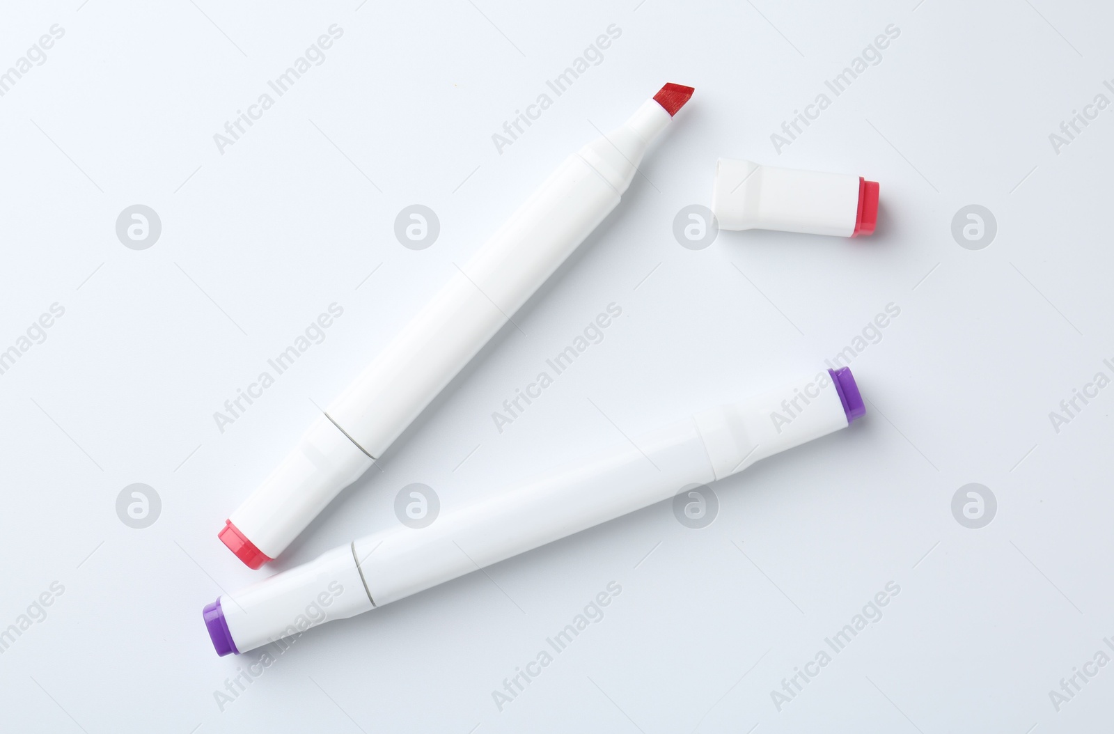 Photo of Colorful double sided markers on white background, flat lay