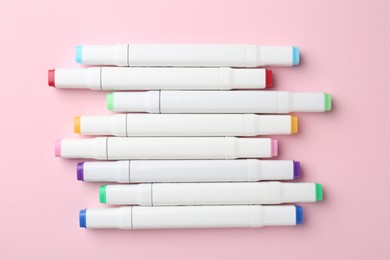 Colorful double sided markers on pink background, flat lay