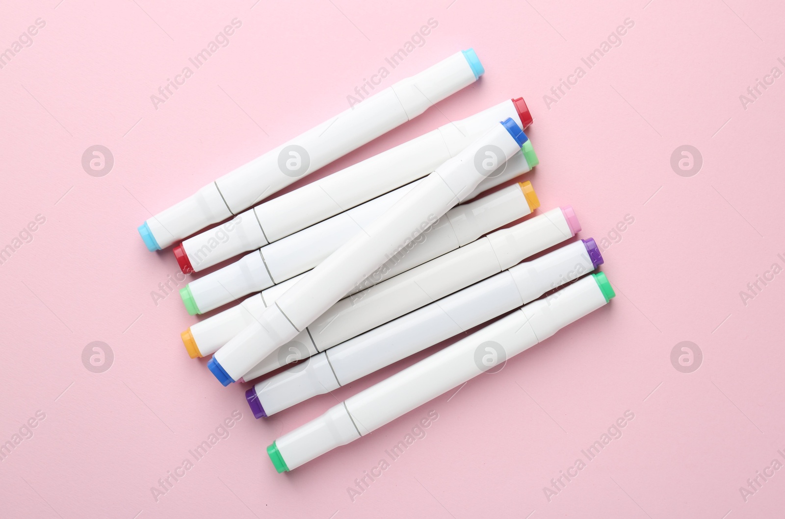 Photo of Colorful double sided markers on pink background, flat lay