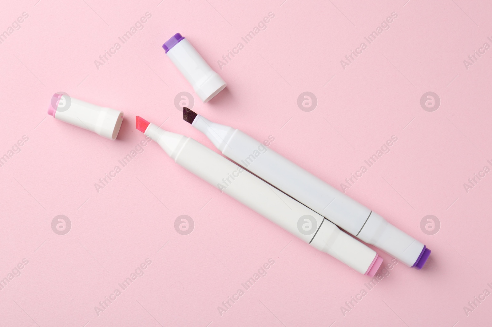 Photo of Colorful double sided markers on pink background, flat lay