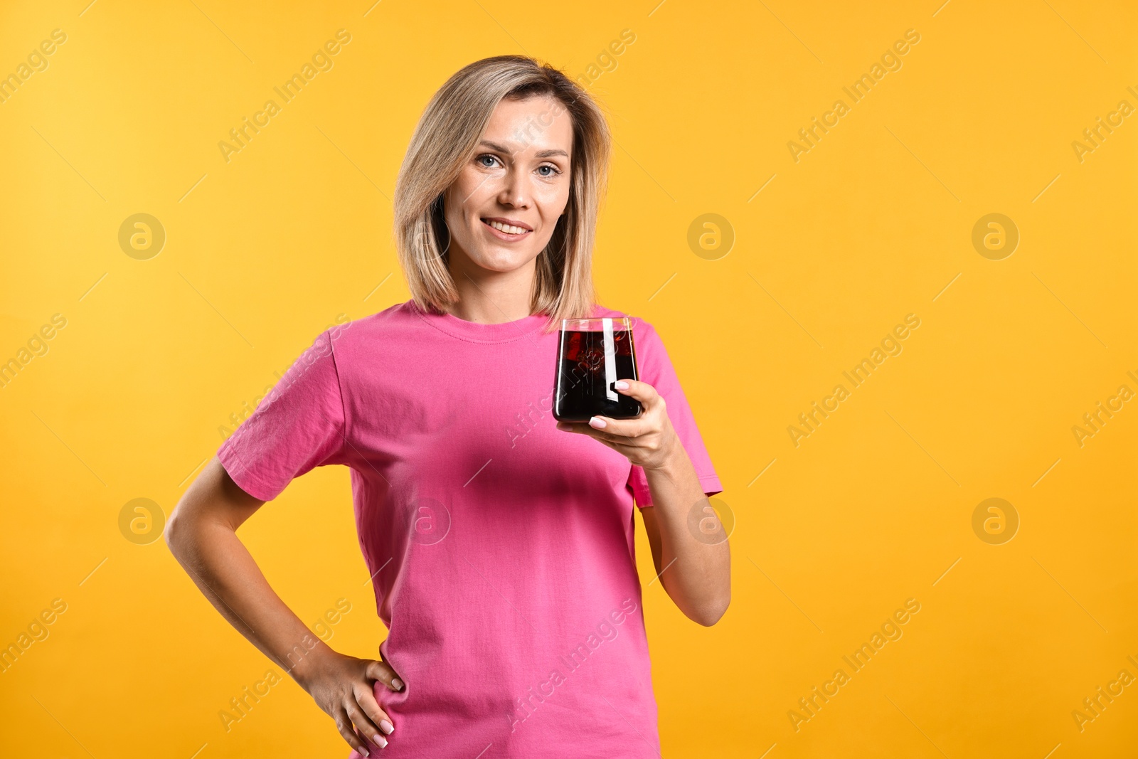 Photo of Woman with glass of refreshing soda drink on orange background