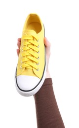 Woman with stylish yellow sneaker on white background, closeup