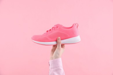 Photo of Woman with stylish sneaker on pink background, closeup