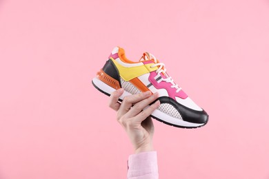 Photo of Woman with stylish sneaker on pink background, closeup