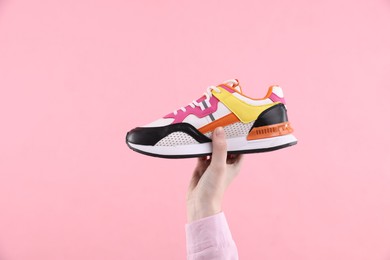 Photo of Woman with stylish sneaker on pink background, closeup