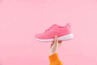 Photo of Woman with stylish sneaker on pink background, closeup