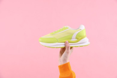 Photo of Woman with stylish sneaker on pink background, closeup