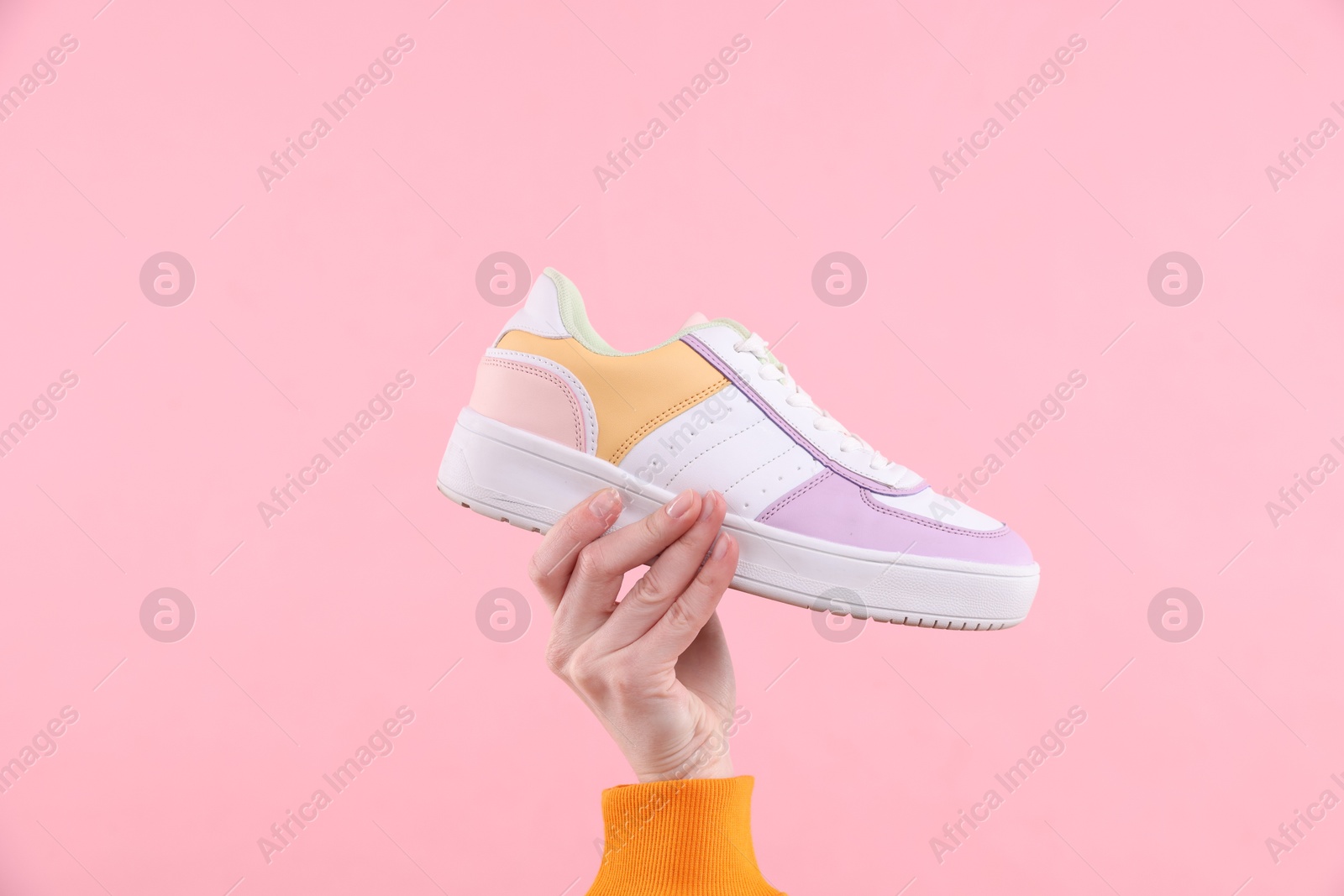 Photo of Woman with stylish sneaker on pink background, closeup