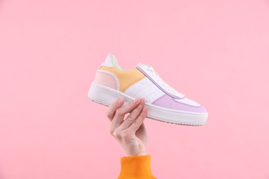 Photo of Woman with stylish sneaker on pink background, closeup