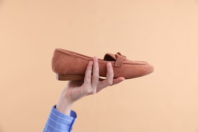 Photo of Woman with stylish shoe on beige background, closeup