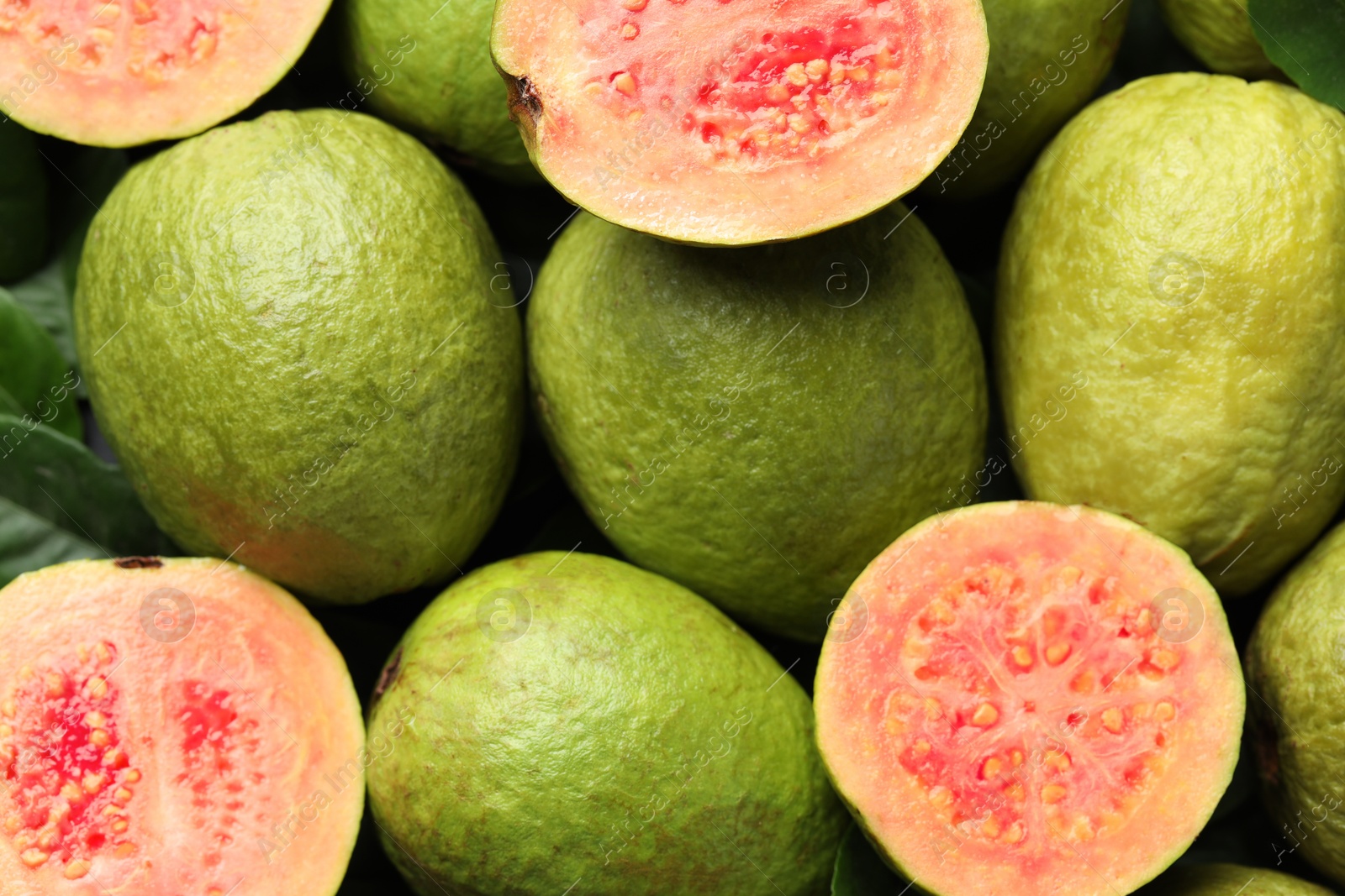 Photo of Fresh cut and whole guava fruits as background, top view