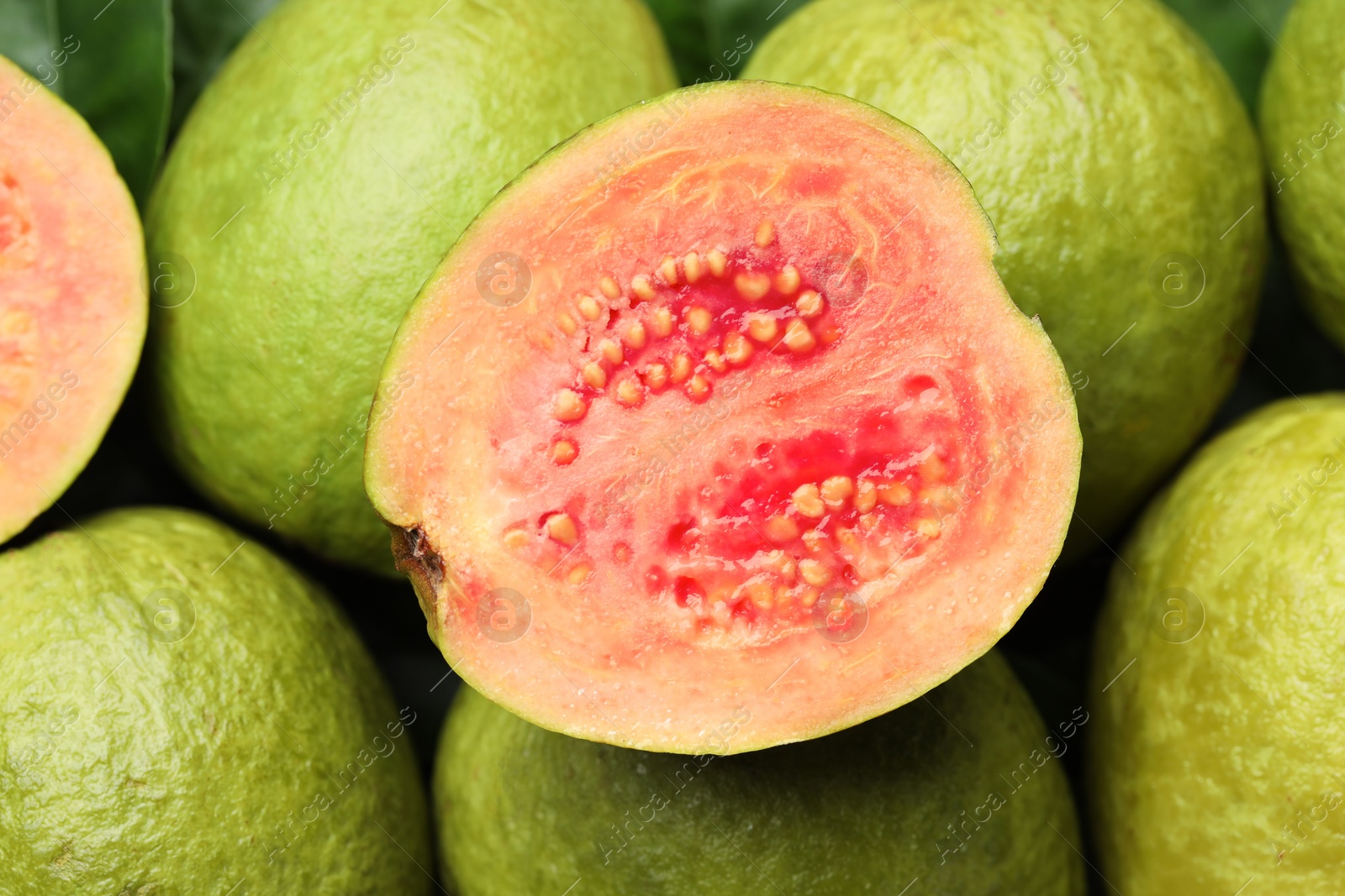 Photo of Fresh cut and whole guava fruits as background, closeup