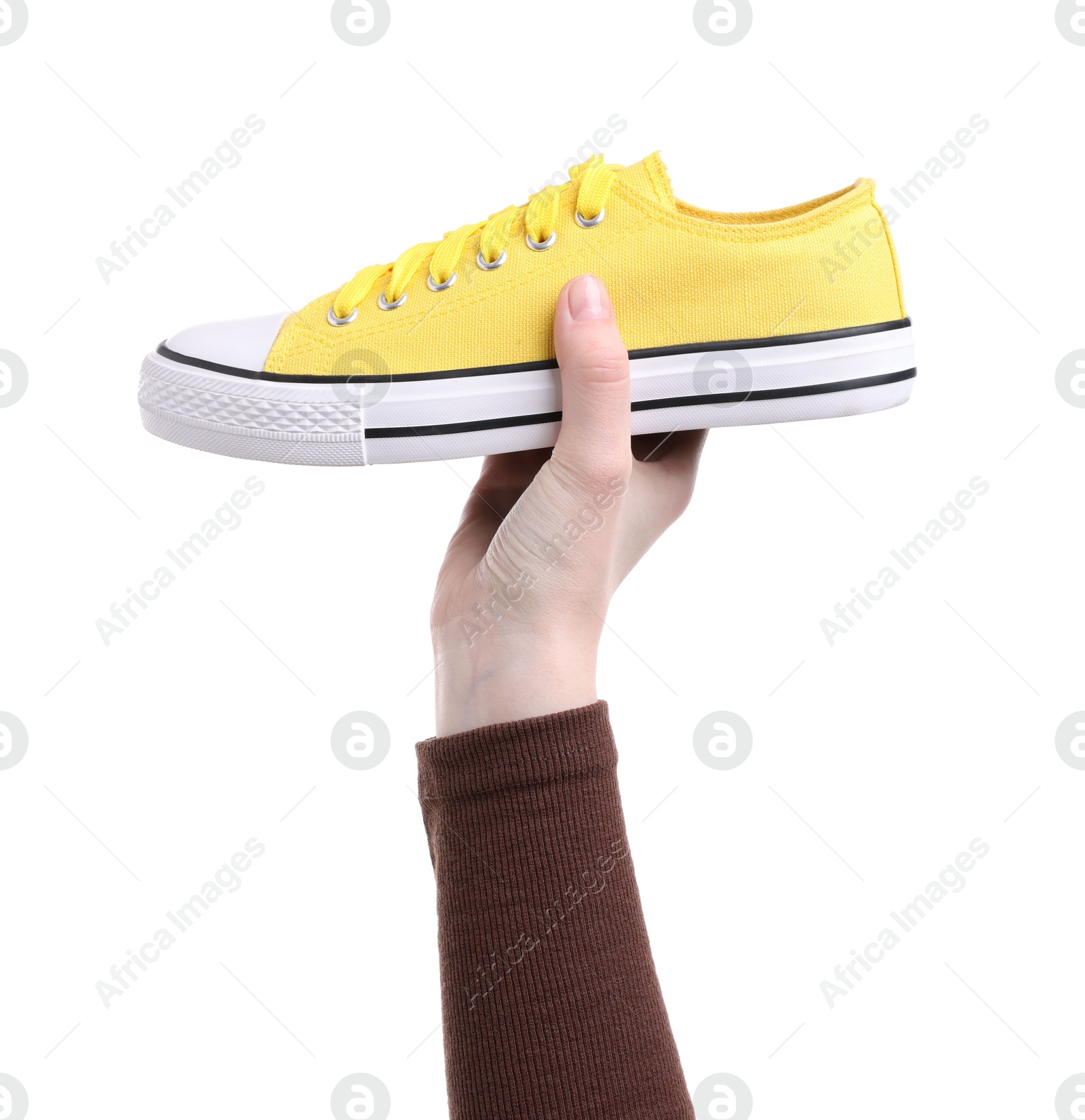 Photo of Woman with stylish yellow sneaker on white background, closeup